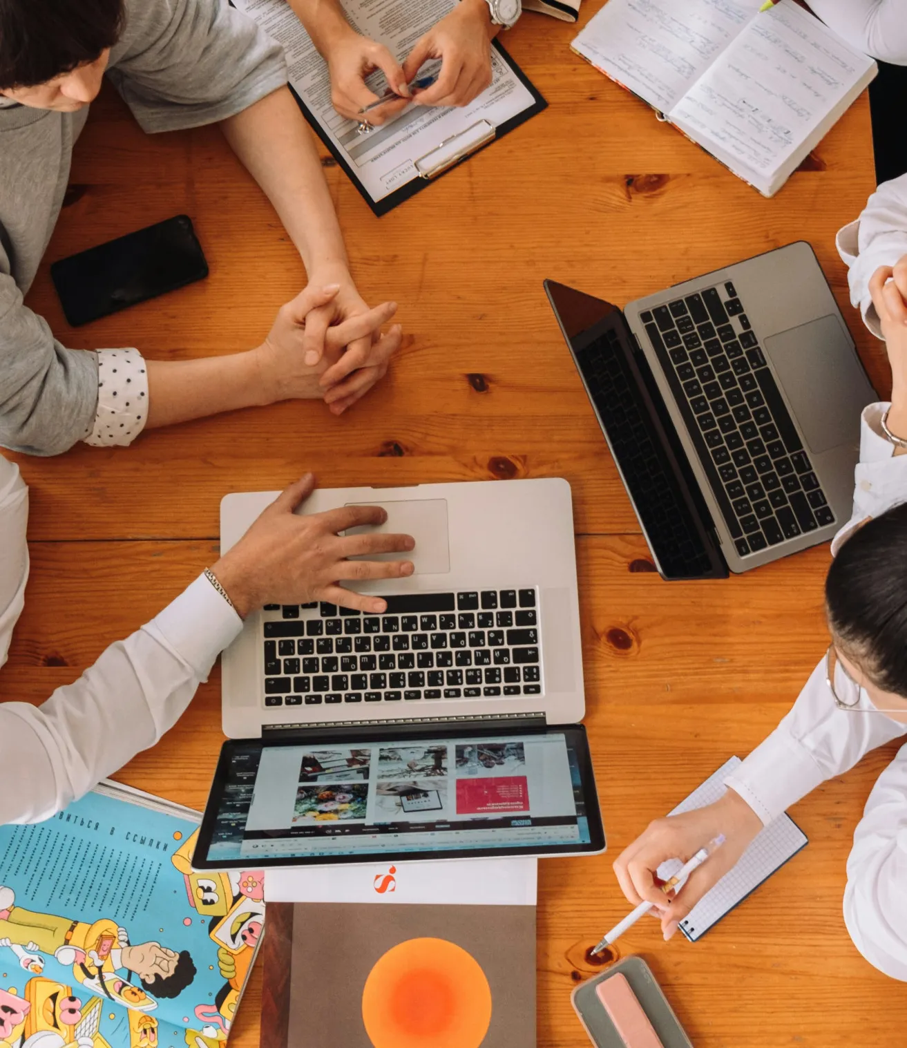 A group of people working around a computer